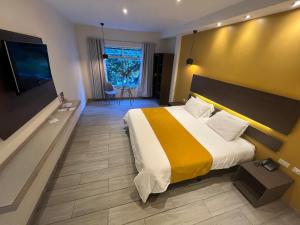 a hotel room with a bed and a flat screen tv at Monte Selva Hotel Spa Termal in Baños