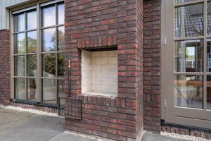 a brick fireplace on the side of a building at Huize Duingeluk in Schoorl
