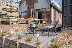 two chairs and a table in front of a house at Huize Duingeluk in Schoorl
