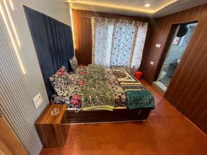 a bedroom with a large bed with a wooden floor at New Heaven Rose in Pahalgām