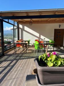 a balcony with tables and chairs and a planter with flowers at B Vishe Guest House in Gjirokastër