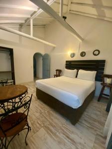 a bedroom with a large white bed and a table at HOTEL BOUTIQUE Santa Helena in Villa de Leyva +84 photos