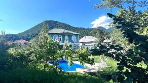 a blue house with a swimming pool in a yard at Mountain View Deluxe Villa & pool in Gabala