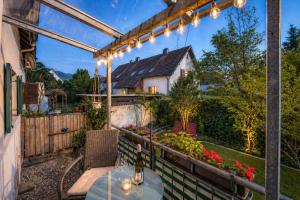 a patio with a table and some lights at Modernes Ferienhaus Dornbirn mit 2 Schlafzimmern 2 Bädern nahe Bodensee & Bregenzerwald in Dornbirn