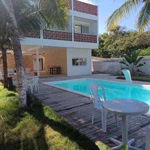 a villa with a swimming pool and a house at Kitnet Terreo Privada 1 in Conde
