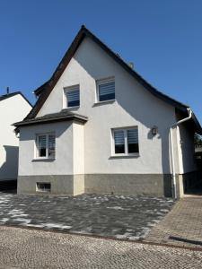 a white house with windows on a street at Ferienwohnung Ruhepunkt Dessau - zentral nahe Bauhaus und Meisterhäusern - mit gratis WLAN und Parken sowie Komplettküche in Dessau