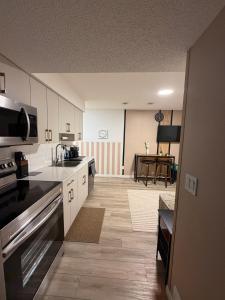 a kitchen with white cabinets and a table in it at Haverims Cozy and Neat Basement in Edmonton