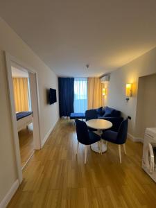 a living room with a couch and a table and chairs at Batumi Best View in Batumi