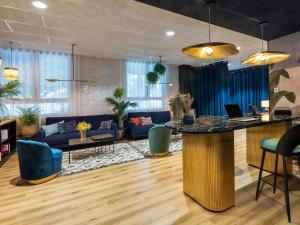 a lobby with a bar and a living room at Mercure La Roche Sur Yon in La Roche-sur-Yon