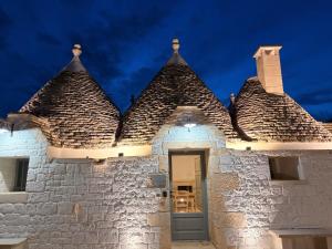 a white stone building with two towers with a door at Luxury Trulli di Giulia, exclusive villa with private pool in Valle d'Itria Ostuni - BR, Puglia in Ostuni