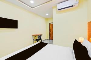a bedroom with a bed and a tv on the wall at Hotel O Madlen in Hyderabad