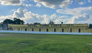 a hotel tenure centre with a field in the foreground at Hotel Torre Forte in Água Boa