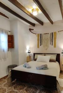 a bedroom with a large bed with two towels on it at El Rincón de la Magia in Soportújar +17 photos