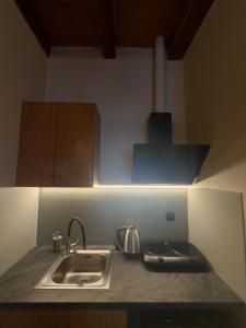 a kitchen counter with a sink and a stove at Kyriakos Apartments in Politika +11 photos