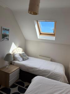 a attic bedroom with two beds and a window at Ballard Down View, Swanage 2 Bed in Swanage