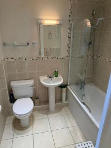 a bathroom with a toilet and a sink and a shower at Ballard Down View, Swanage 2 Bed in Swanage +26 photos