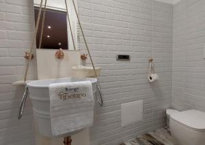 a white bathroom with a toilet and a towel at Borgo Tibetano in Castelsaraceno +22 photos