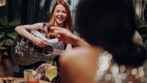 Eine Frau, die vor einem Spiegel eine Gitarre hält. in der Unterkunft Ruby Molly Hotel Dublin by IHG in Dublin