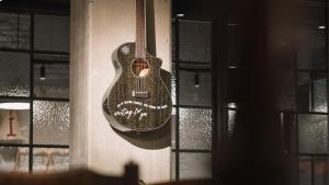 Eine Gitarre hängt an einer Wand neben einem Fenster in der Unterkunft Ruby Molly Hotel Dublin by IHG in Dublin + 77 Fotos