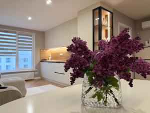 a vase filled with purple flowers sitting on a table at Inamstro Home in Orhei