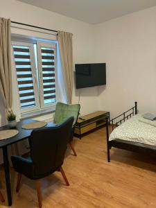 a living room with a bed and a table and chairs at Apartamenty Rybna 1 Centrum in Tarnów