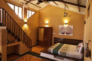 a bedroom with a bed and a staircase at Surwahi Social Ecoestate Kanha in Kānha
