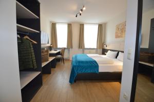 a hotel room with a bed and a desk and a bedroom at Boardinghouse Hotel Münchner Hof Pfarrkirchen in Pfarrkirchen +55 photos