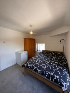 a bedroom with a bed with a black and white comforter at Serenity LTD in Leicester