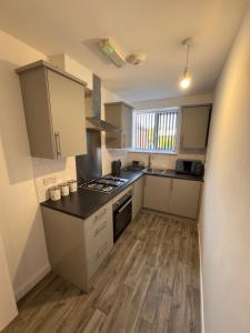 a large kitchen with a stove and a sink at Serenity LTD in Leicester +3 photos