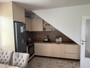 a kitchen with white cabinets and a refrigerator at Butmir house-Sarajevo in Sarajevo