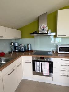 a kitchen with white cabinets and a stove top oven at Mountain and Lake in Bönigen +41 photos