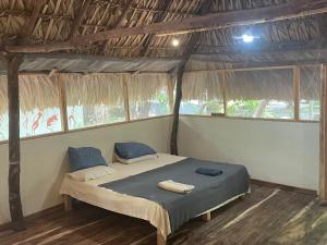 a bedroom with a bed in a room with windows at Bokané in Boca del cielo