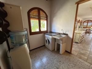 a bathroom with a washing machine and a sink at L'Estança de Can Rodó in Vilobí d'Onyar +6 photos