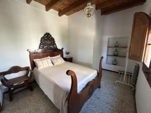 a bedroom with a large bed and a chair at L'Estança de Can Rodó in Vilobí d'Onyar