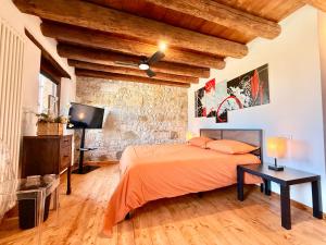 a bedroom with a bed and a tv in a room at Villa Saten in Pavia dʼUdine