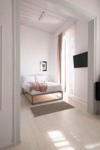 ein weißes Schlafzimmer mit einem Bett und einem Fenster in der Unterkunft Araldo in Chania