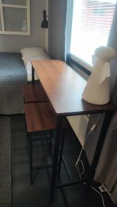 a desk in a room with a bed and a lamp at Hartikkalan Apartments in Lappeenranta