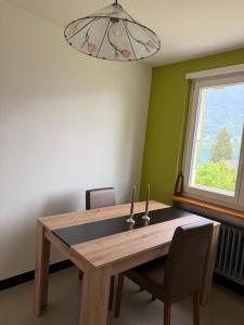 a dining room with a wooden table and a window at Mountain and Lake in Bönigen