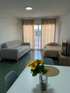 a living room with a couch and a table with flowers at Cullera Beach III in Cullera