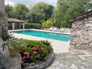 a swimming pool with flowers in a yard at Luxurious Provencal cottage with private Pool, Terrace & Garden in Vence