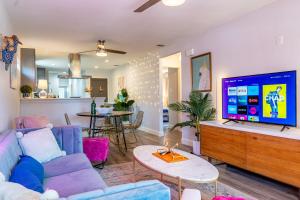 a living room with a blue couch and a flat screen tv at Southtown 3BR Cowboy Pool, Playset, Riverwalk, BBQ, Firepit, Big Yard — Downtown San Antonio in San Antonio
