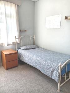 a bedroom with a bed and a dresser and a window at Sawston Village in Sawston