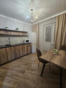 a kitchen and dining room with a table and a refrigerator at Бауржан Момушелы 28 in Fëdorovka