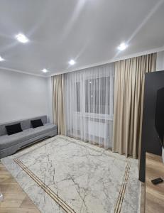 a living room with a couch and a window at Бауржан Момушелы 28 in Fëdorovka