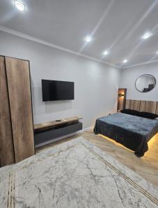 a bedroom with a bed and a flat screen tv at Бауржан Момушелы 28 in Fëdorovka