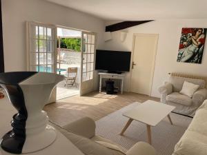 a living room with a couch and a tv at Luxurious Provencal cottage with private Pool, Terrace & Garden in Vence