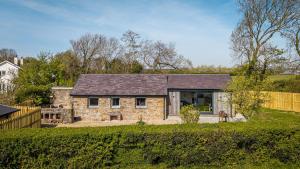 a stone house with a black roof at Pen Lon Quirt in Newborough