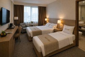 a hotel room with two beds and a desk at Simge Suite Hotel in Istanbul