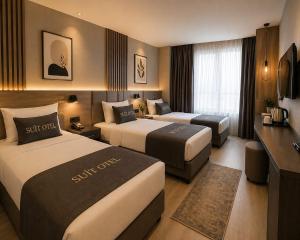 a hotel room with two beds and a television at Simge Suite Hotel in Istanbul +24 photos