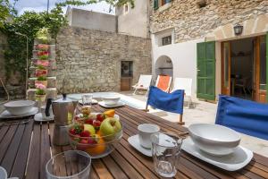 a wooden table with a bowl of fruit on it at Ca Sa Padrina in Artá